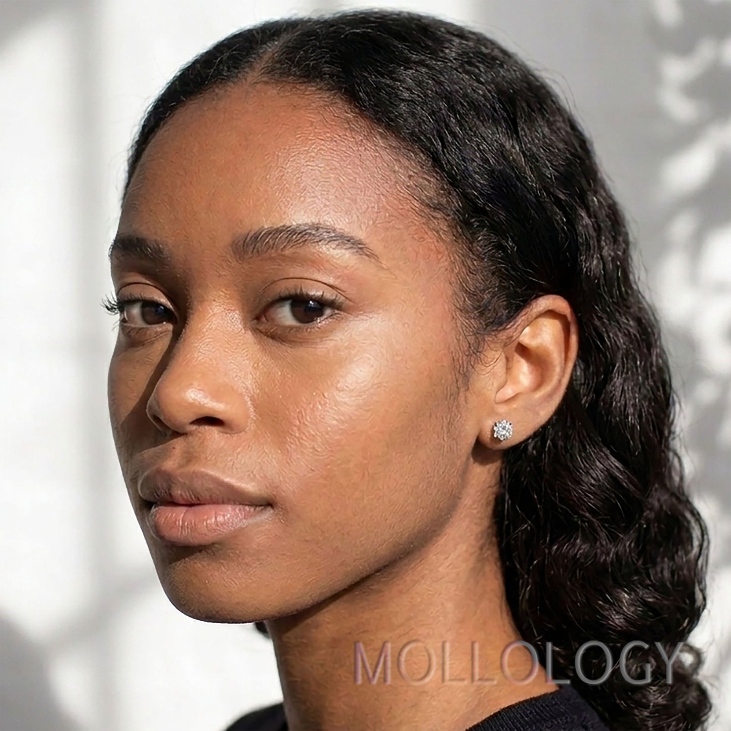 Model wearing a small gold diamond-accent star stud earring.