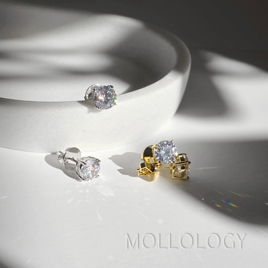 Gold and white gold CZ solitaire stud earrings together on white dish, mixed metal diamond-style studs