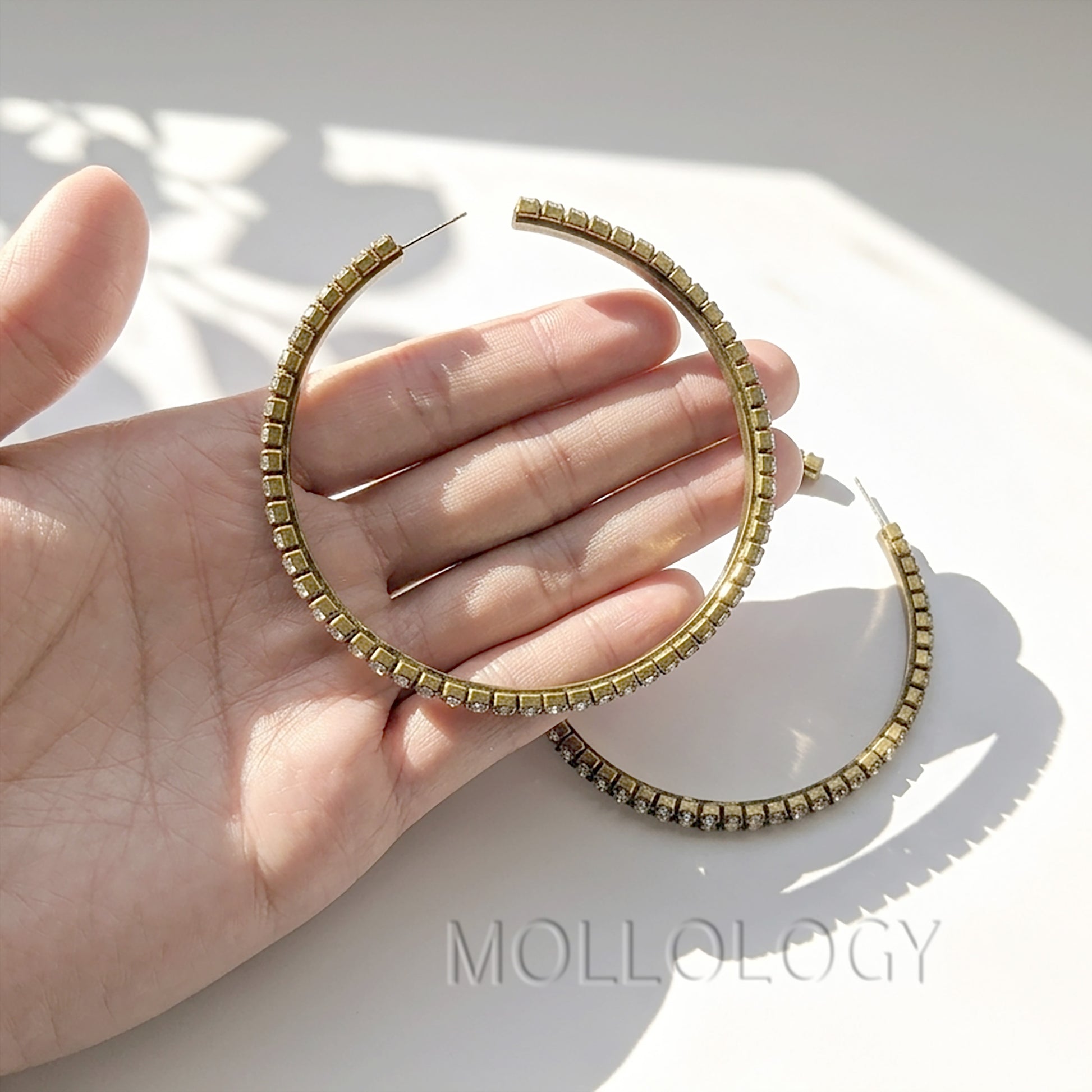 Large gold CZ hoop earrings shown on white background, elegant sparkly statement jewelry product photo by MOLLOLOGY.
