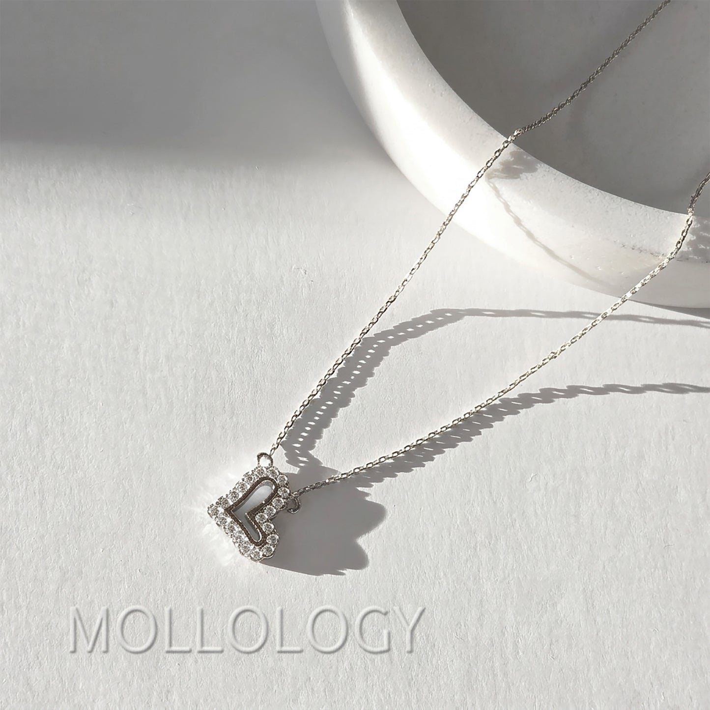 Silver pave heart pendant necklace on white tray, sparkling minimalist CZ heart jewelry product photo by MOLLOLOGY.
