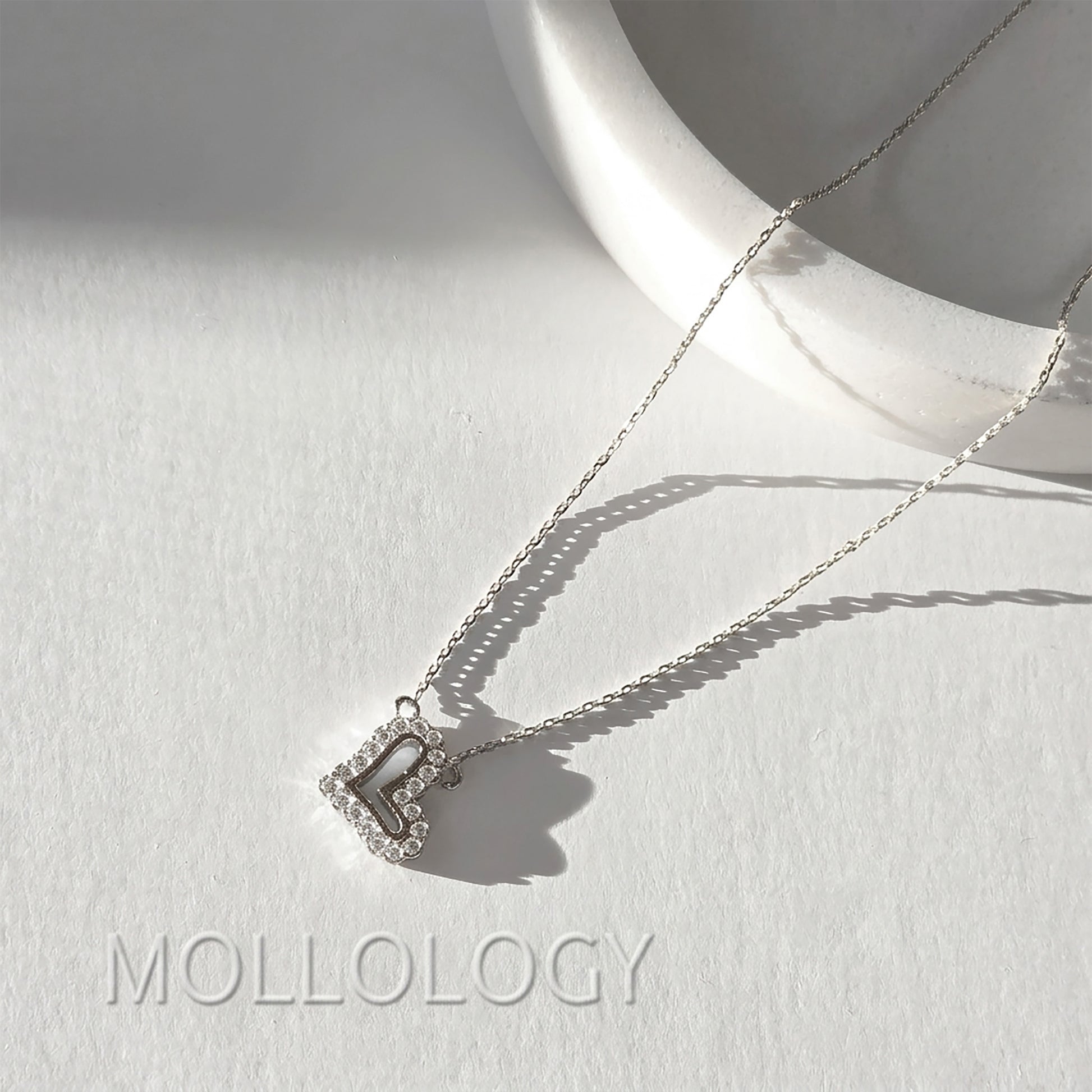 Silver pave heart pendant necklace on white tray, sparkling minimalist CZ heart jewelry product photo by MOLLOLOGY.