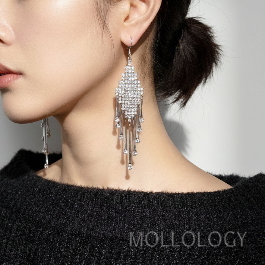 Model wearing silver CZ teardrop dangle earrings, closeup profile showing fringe strands against black sweater