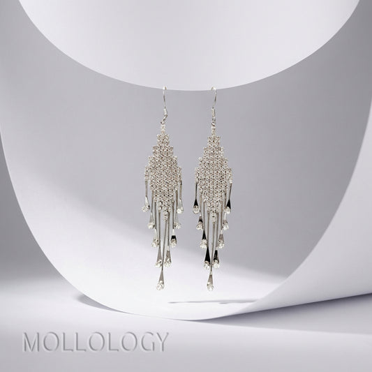 Pair of silver crystal dangle earrings hanging on white curved holder, dainty wedding drop earrings sparkling