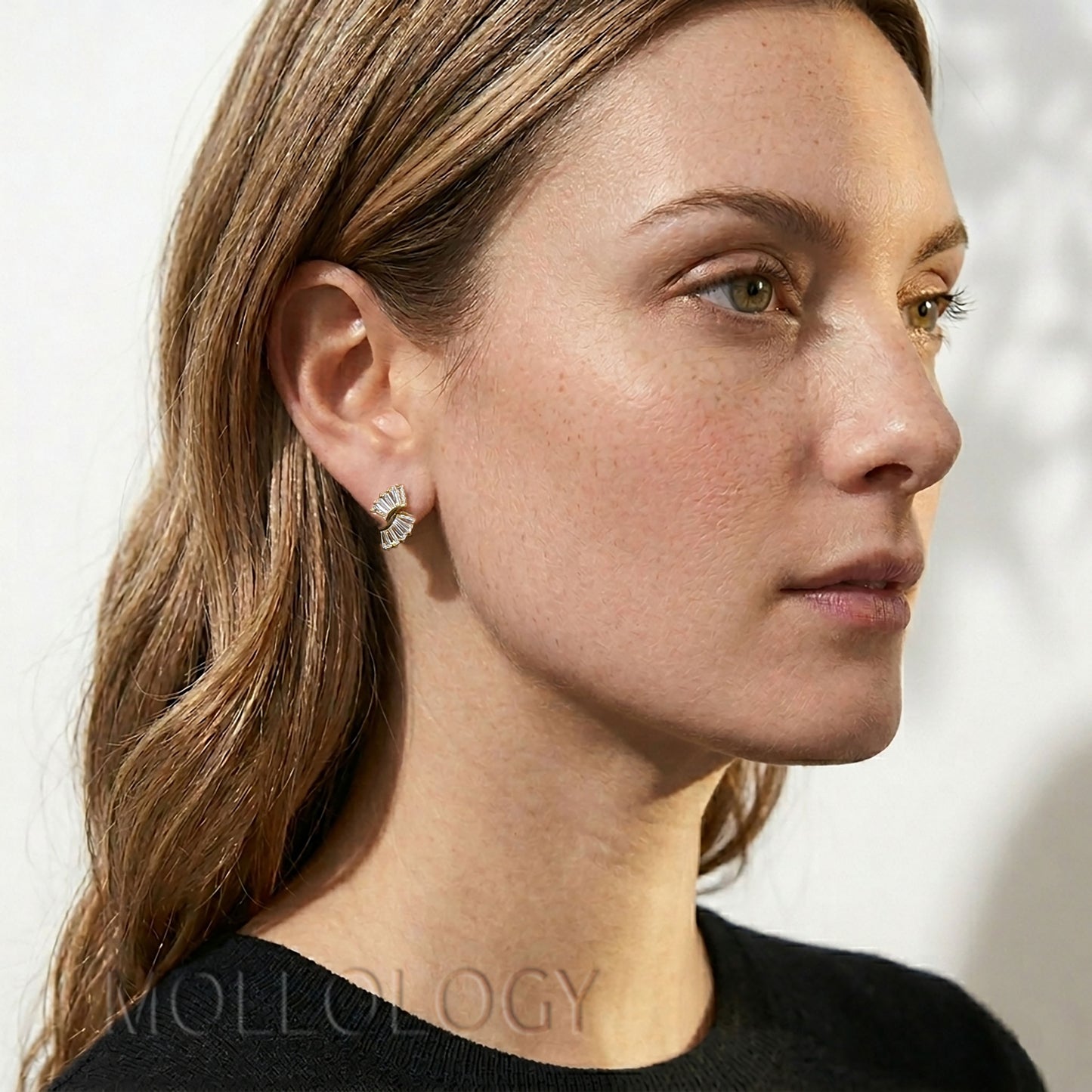 Model wearing dainty art deco baguette fan stud earrings with a geometric design.