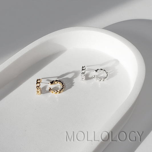 Gold and silver chainlink huggie earrings shown side by side on a white tray.
