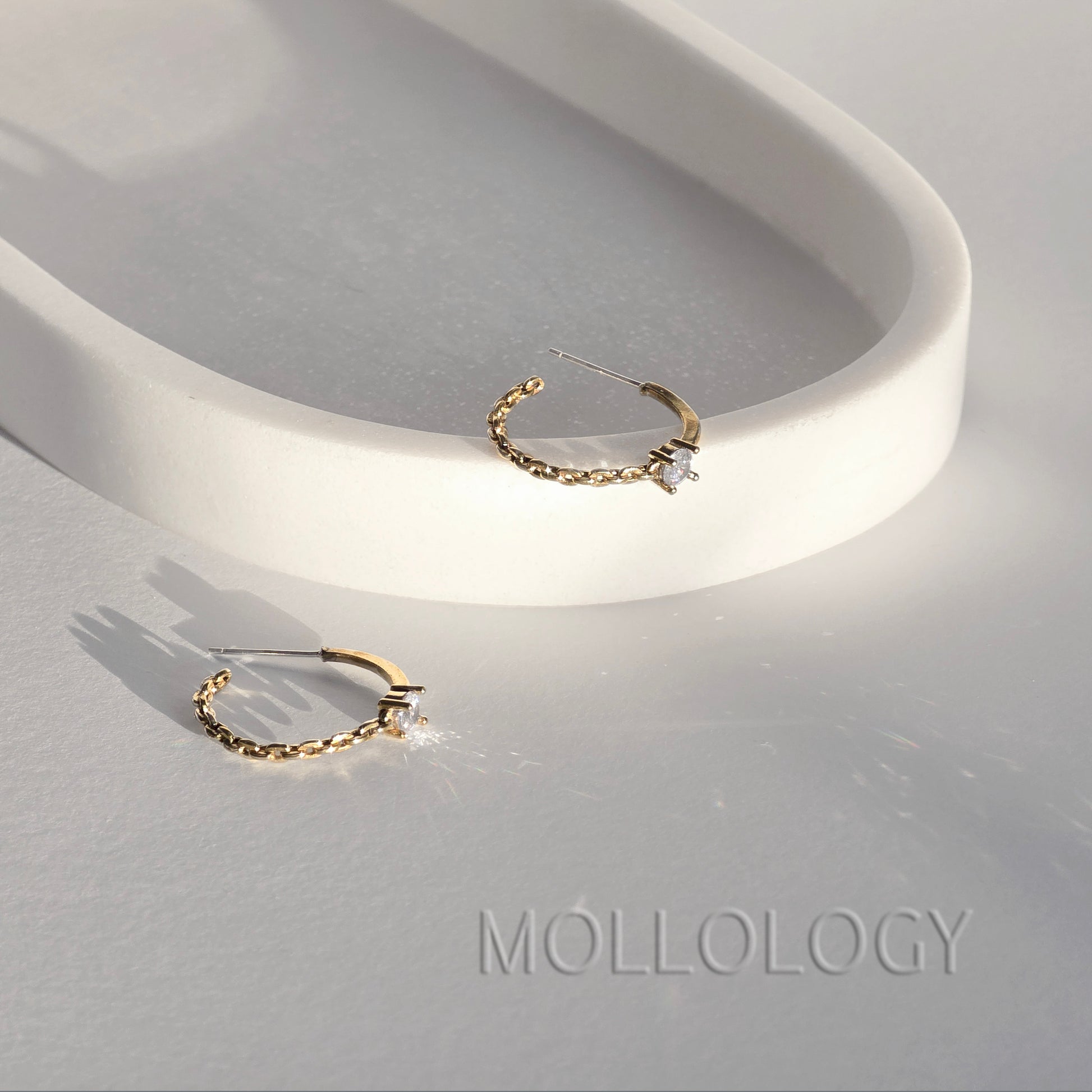 Dainty gold chain hoop earrings with CZ stone on white tray, minimalist MOLLOLOGY jewelry product photo.