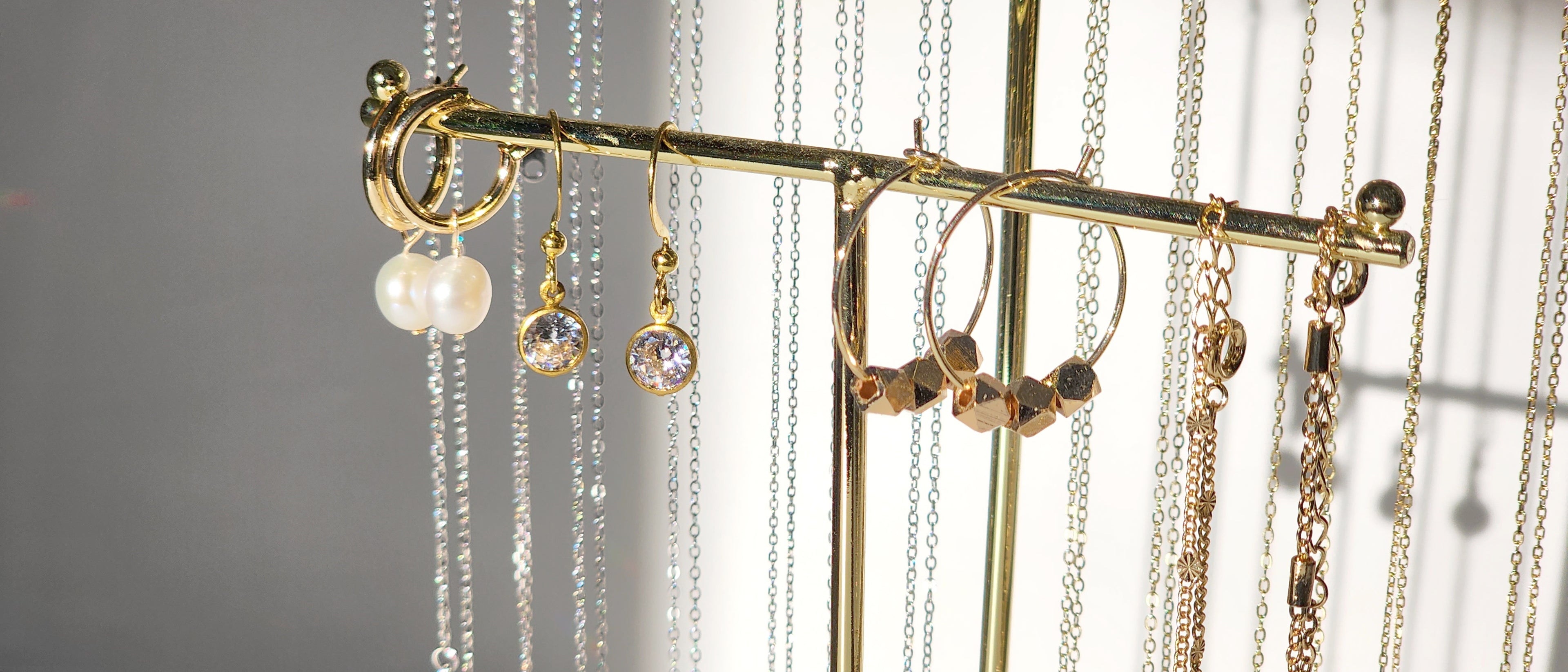 Minimalist gold necklace with pearl stud earrings and gold hoop earrings