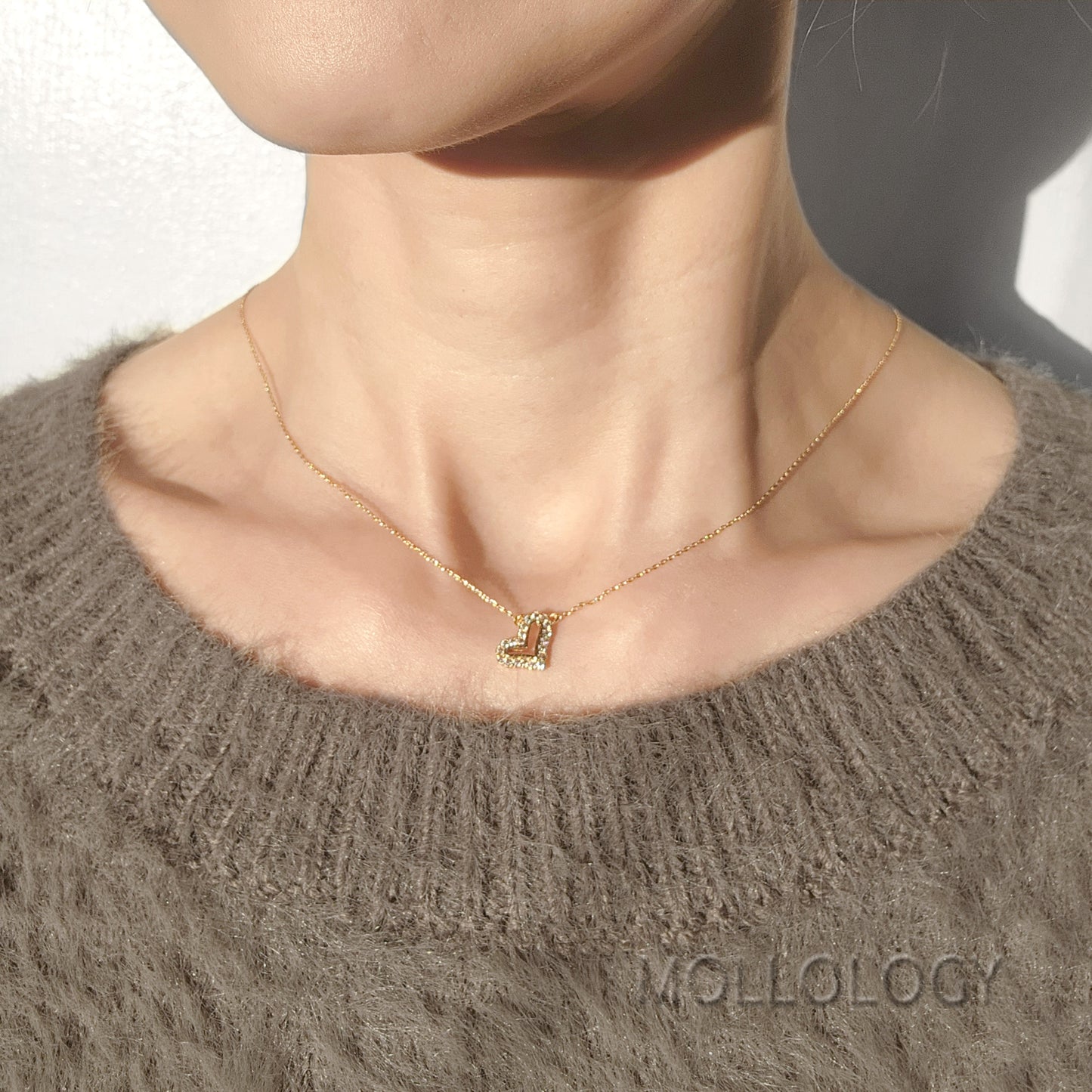Dainty gold heart necklace with pave CZ stones on model, minimalist everyday love pendant by MOLLOLOGY.
