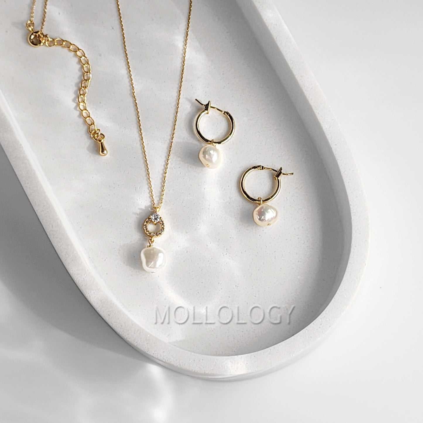 These Freshwater Pearl Huggies feature lustrous natural pearls on dainty gold huggie hoops, creating an elegant yet minimalist look that works for every day. Perfect as everyday pearl earrings or for dressing up, these lightweight hoops are ideal for layering with other earrings and make a beautiful gift for her.