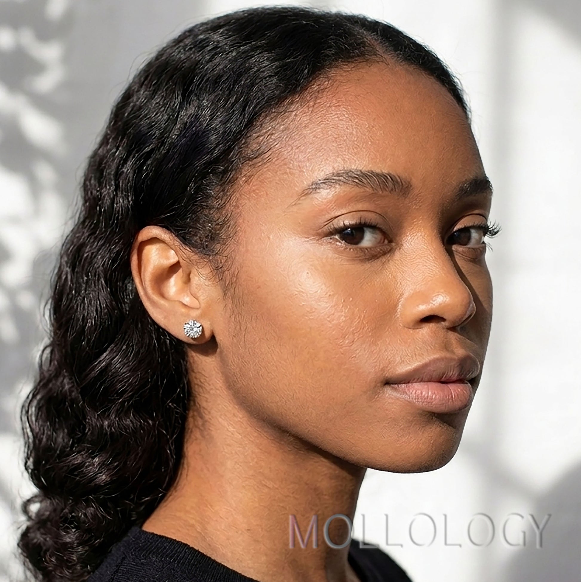 Model wearing silver diamond stud on her ear.