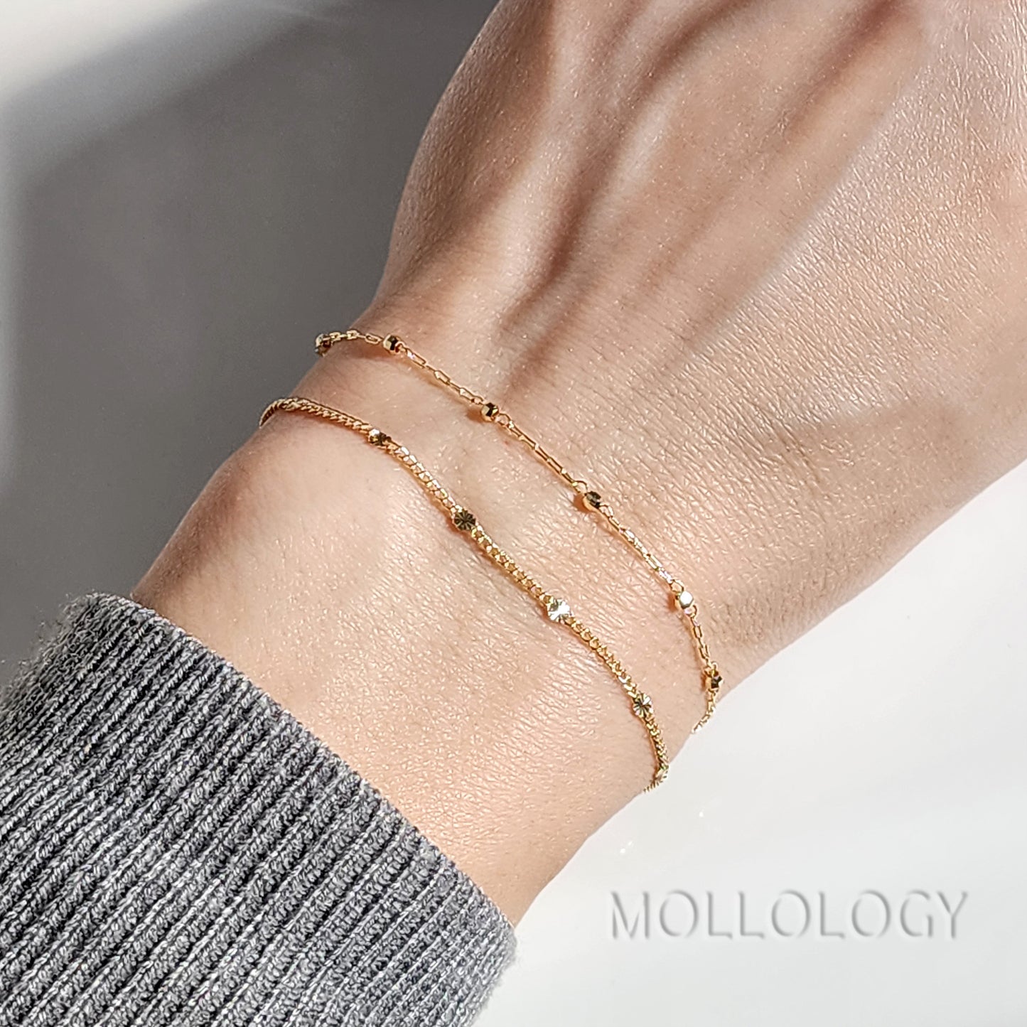 Close-up of the 1-inch extension chain and lobster claw clasp on a dainty gold bracelet for an adjustable fit.