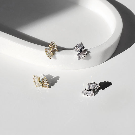 Gold and silver art deco baguette fan stud earrings shown close-up in a bright studio setting.