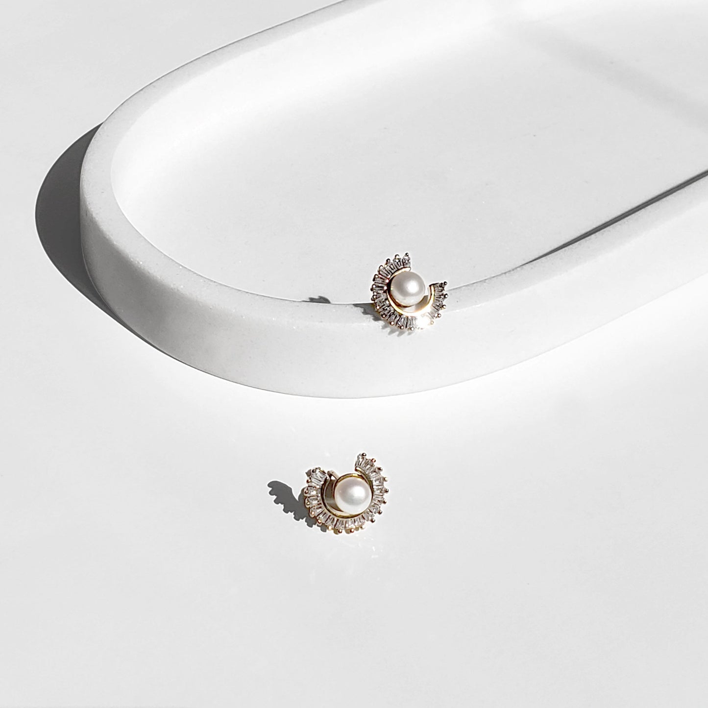Freshwater Pearl Sunburst Stud Earrings blend modern sparkle with timeless elegance. Designed with a radiant baguette CZ sunburst framing a lustrous freshwater pearl, these studs bring a luxurious yet minimalist touch to any style perfect for everyday wear or special occasions.