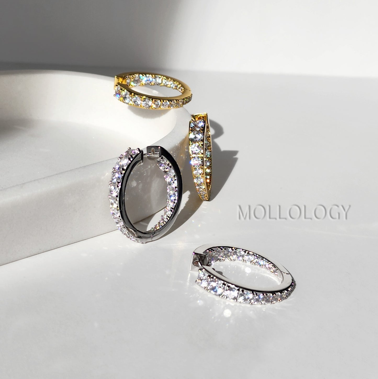 Close-up of pave diamond hoop earrings, showing in 14K gold finish and white gold finish