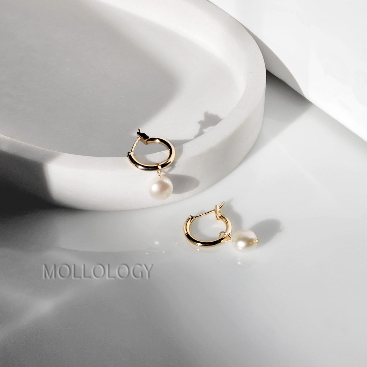 These Freshwater Pearl Huggies feature lustrous natural pearls on dainty gold huggie hoops, creating an elegant yet minimalist look that works for every day. Perfect as everyday pearl earrings or for dressing up, these lightweight hoops are ideal for layering with other earrings and make a beautiful gift for her.