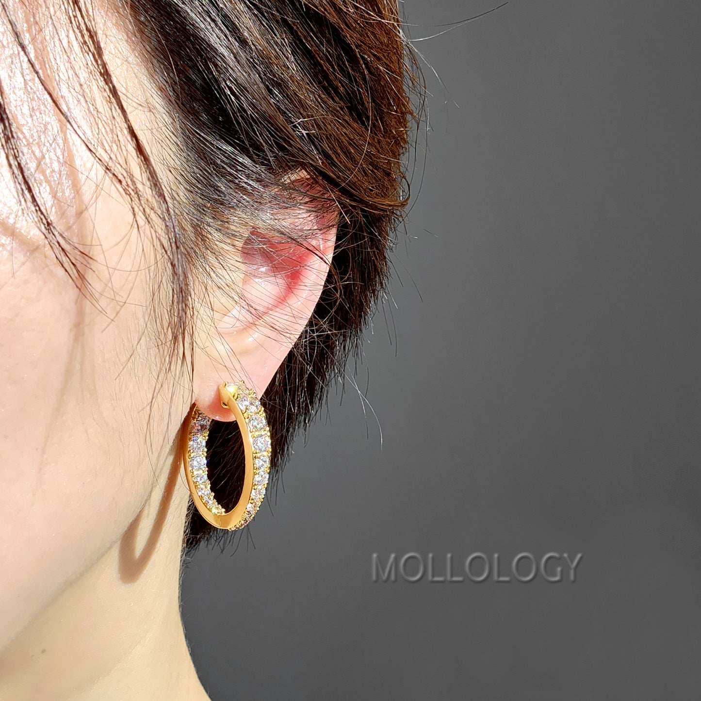 close-up of a model wearing 14k gold pave hoop earring