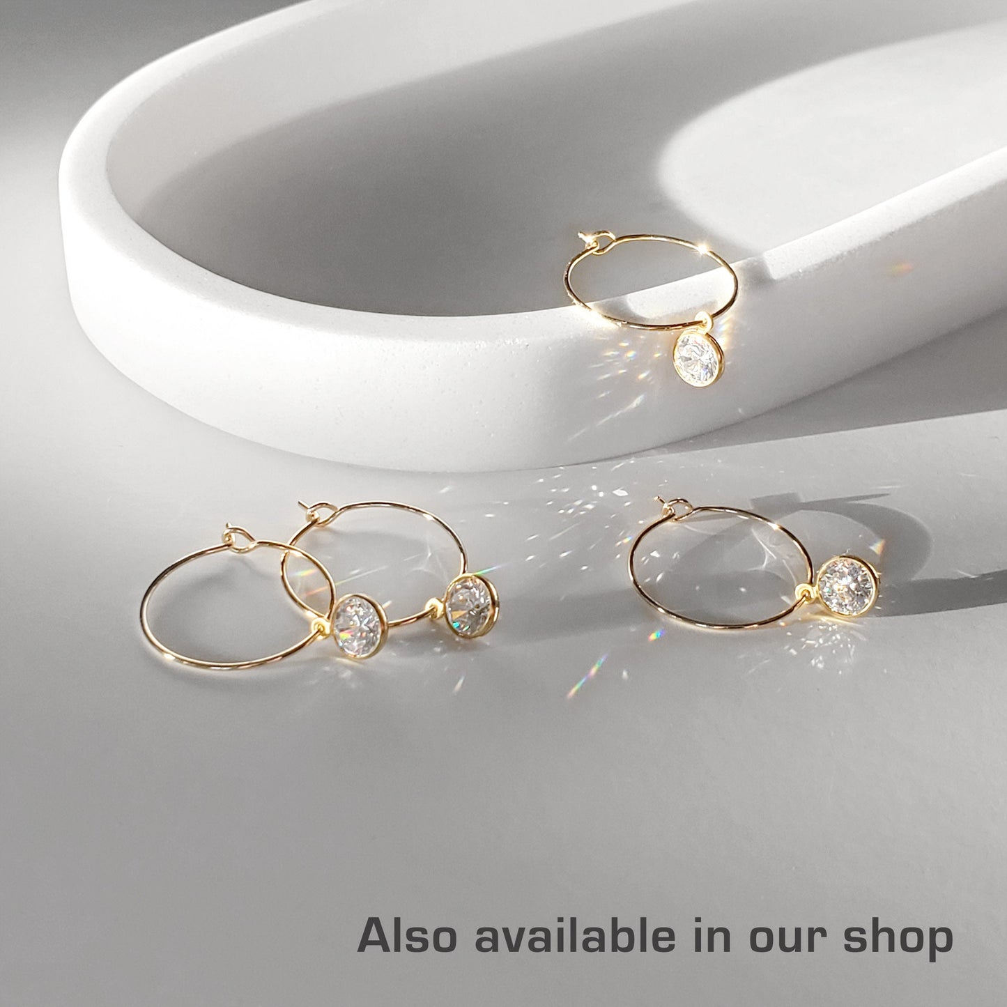 A set of gold-colored hoop earrings in various sizes, designed in the shape of hearts, displayed on a white surface.