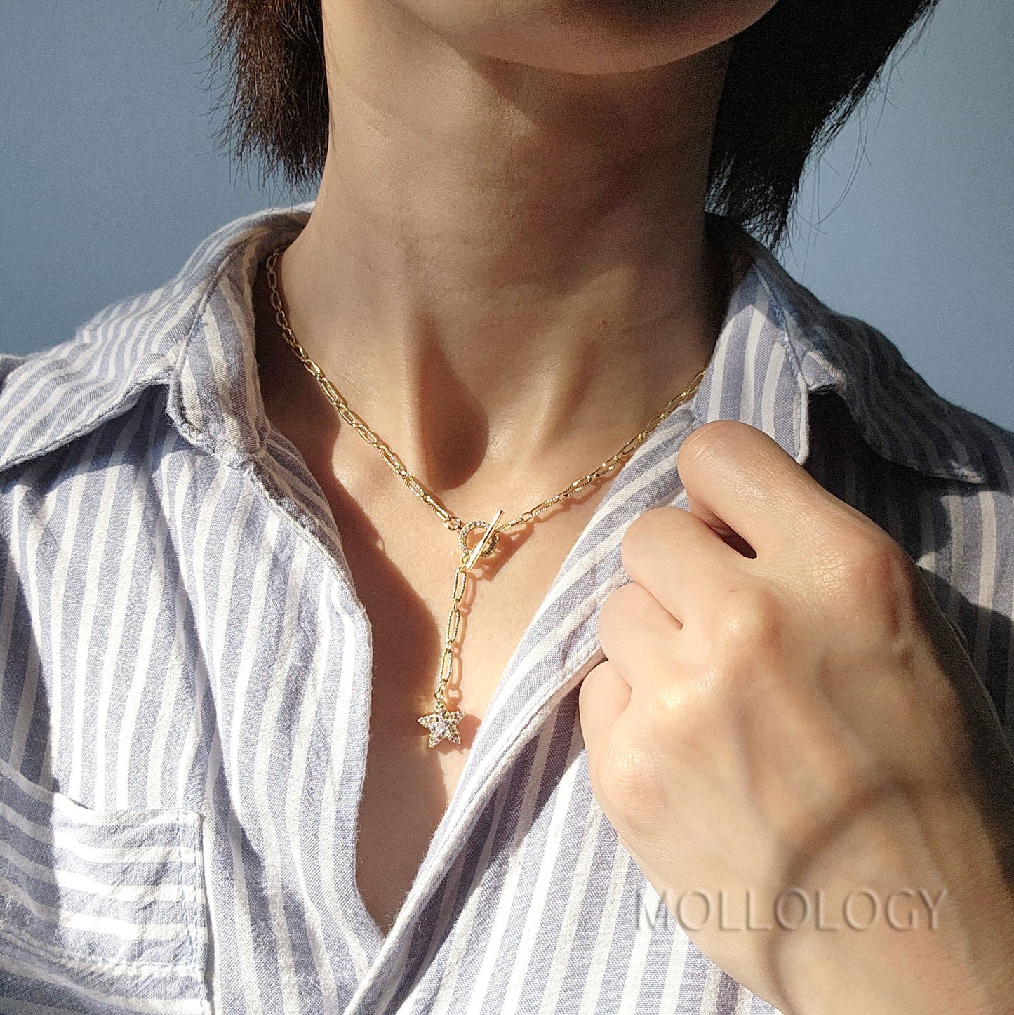  a gold chain link necklace with a star charm