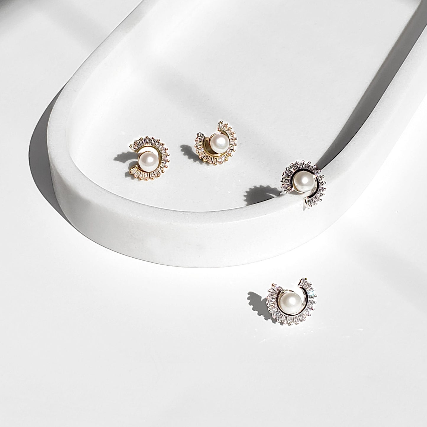 Freshwater Pearl Sunburst Stud Earrings blend modern sparkle with timeless elegance. Designed with a radiant baguette CZ sunburst framing a lustrous freshwater pearl, these studs bring a luxurious yet minimalist touch to any style perfect for everyday wear or special occasions.