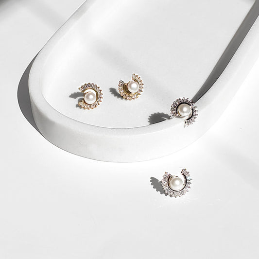 Freshwater Pearl Sunburst Stud Earrings blend modern sparkle with timeless elegance. Designed with a radiant baguette CZ sunburst framing a lustrous freshwater pearl, these studs bring a luxurious yet minimalist touch to any style perfect for everyday wear or special occasions.