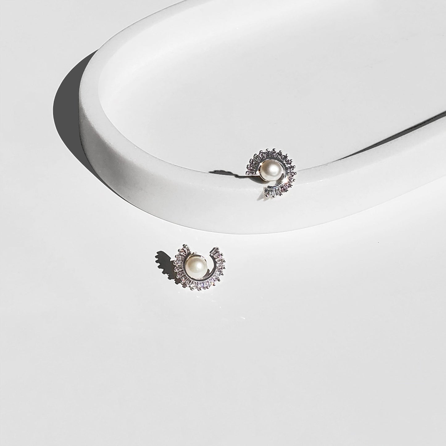 Freshwater Pearl Sunburst Stud Earrings blend modern sparkle with timeless elegance. Designed with a radiant baguette CZ sunburst framing a lustrous freshwater pearl, these studs bring a luxurious yet minimalist touch to any style perfect for everyday wear or special occasions.